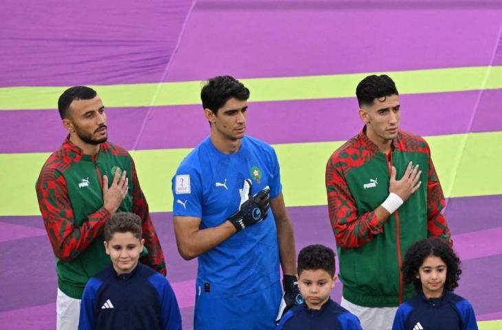 Kiper Maroko, Yassine Bounou (tengah) menyanyikan lagu kebangsaan mereka menjelang dimulainya pertandingan Grup F Piala Dunia 2022 melawan Belgia di Stadion Al-Thumama di Doha pada 27 November 2022. (AFP/Glyn Kirk)