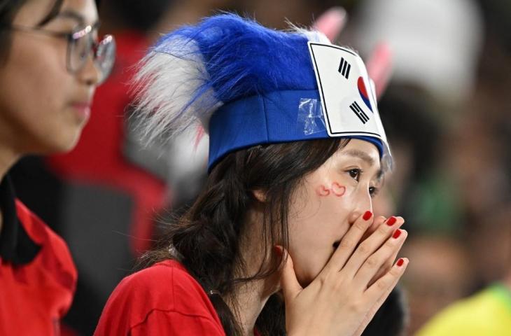 Seorang pendukung Korea Selatan terlihat sedih setelah timnya kalah 1-4 dari Brasil di babak 16 besar Piala Dunia 2022 di Stadion 974 di Doha pada 5 Desember 2022. (AFP/Manan Vatsyayana)