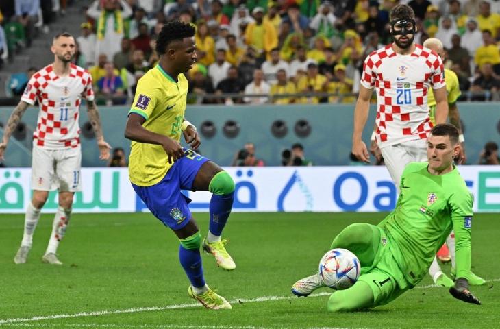 Kiper Kroasia, Dominik Livakovic menghalau tendangan dari penyerang Brasil, Vinicius Jr pada perempat final Piala Dunia di Stadion Education City, Qatar, Jumat (9/12/2022). (Twitter/@CBSSportsGolazo)