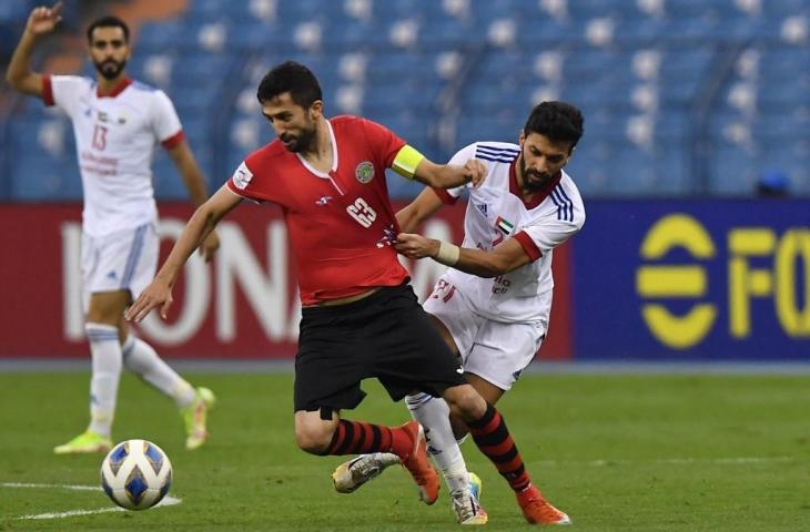 Gelandang Sharjah Abdullah Kazim (kanan) menarik baju pemain depan Istiklol Manuchekhr Dzhalilov (tengah) selama pertandingan Grup A Liga Champions AFC pada 27 April 2022, di stadion King Fahd di ibukota Saudi, Riyadh. (AFP)