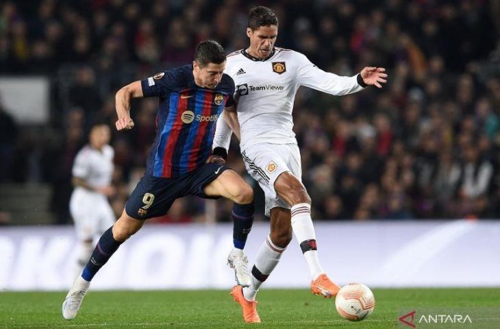 Penyerang Barcelona Robert Lewandowski (kiri) berebut bola dengan bek Manchester United Raphael Varane dalam pertandingan leg pertama babak 32 besar Liga Europa di Camp Nou pada 16 Februari 2023. ANTARA/AFP/JOSEP LAGO