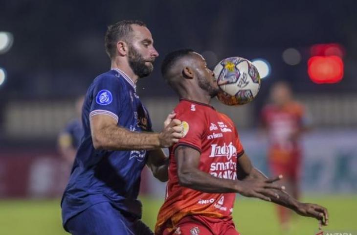 Pesepak bola Arema FC Sergio Domingos (kiri) menghadang pesepak bola Bali United FC Privat Mbarga (kanan) dalam lanjutan Liga 1 di Stadion PTIK, Jakarta, Senin (27/3/2023). Arema FC kalah atas Bali United FC dengan skor 1-3. ANTARA FOTO/Galih Pradipta/rwa. (ANTARA FOTO/GALIH PRADIPTA)