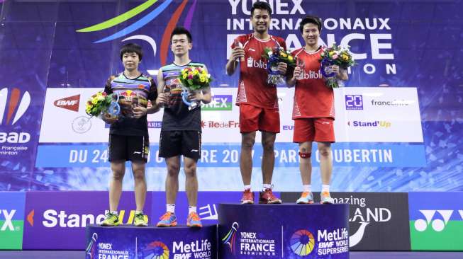 Tontowi Ahmad/Liliyana Natsir berdiri di podium utama usai mengalahkan pasangan ganda campuran Cina, Zheng Siwei/Chen Qingchen (kiri), pada final Prancis Open Super Series 2017, Minggu (29/10). [Humas PSBI]