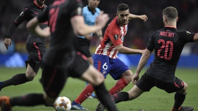 Pemain Atletico Madrid Koke berusaha keluar dai kepungan pemain Arsenal di leg kedua semifinal Liga Europa yang digelar di Estadio Wanda Metropolitano, Jum'at (4/5/2018) [AFP]