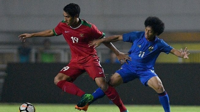 Pemain Timnas Indonesia U-23 Hanif Sjahbandi (kiri) menggiring bola dibayangi pemain Timnas Thailand U-23 Tanasith Siripala dalam pertandingan uji coba di Stadion Pakansari, Cibinong, Bogor, Jawa Barat, Minggu (3/6) malam. ANTARA