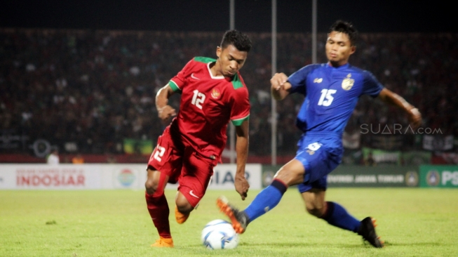 Bek Timnas Indonesia U-19, Rifad Marasabessy (kiri), mencoba melewati hadangan pemain Thailand, Sampan Kesi, dalam laga yang berakhir 1-2 untuk kemenangan Thailand di penyisihan terakhir Grup A Piala AFF U-19 2018 di Stadion Delta Sidoarjo, Jawa Timur, Senin (9/7). [Suara.com/Dimas Angga P]