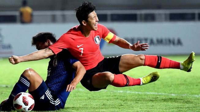 Pemain Korsel Son Heung-min (kanan), dilanggar pesepakbola Jepang, Daiki Sugioka, pada pertandingan perebutan medali emas Asian Games 2018 di Stadion Pakansari,Bogor, Jawa Barat, Sabtu (1/9). [Antara/INASGOC/Dwi Prasetyo]