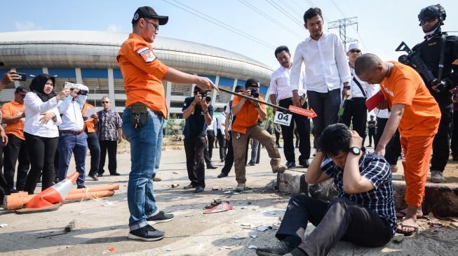 Seorang tersangka memperagakan tindakannya saat rekonstruksi pengeroyokan yang dilakukan oleh oknum bobotoh terhadap seorang suporter Persija, Haringga Sirla, di Stadion Gelora Bandung Lautan Api (GBLA), Bandung, Jawa Barat, Rabu (26/9). Rekontruksi tersebut dilakukan ‎untuk mendapatkan gambaran jelas tentang terjadinya tindak pidana pengeroyokan hingga menghilangkan nyawa Haringga Sirla tersebut, serta untuk menguji kebenaran keterangan para tersangka dan saksi. ANTARA FOTO/Raisan Al Farisi