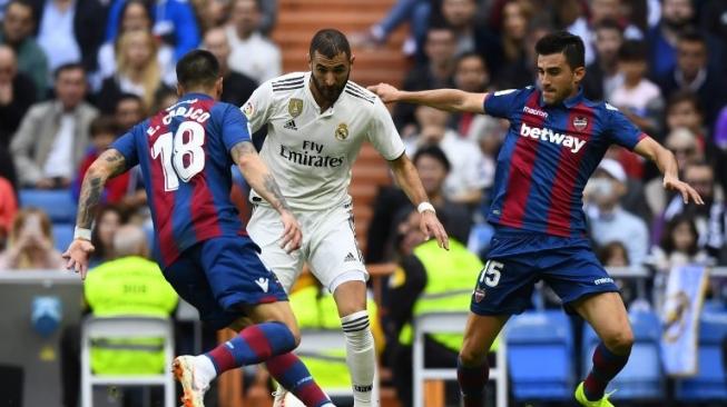 Pemain depan Real Madrid Karim Benzema (tengah) mencoba melewati dua pemain Levante Erick Cabaco (kiri) dan Sergio Postigo di Santiago Bernabeu. GABRIEL BOUYS / AFP