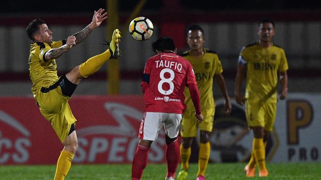 Pesepak bola Bhayangkara FC Paulo Sergio (kiri) berhadapan dengan pesepak bola Bali United FC Taufiq (kedua kiri) dalam pertandingan Liga 1 2018 di Stadion PTIK, Jakarta, Sabtu (8/12/2018). Bhayangkara FC berhasil mengalahkan Bali United FC dengan skor 2-0 dan memastikan posisinya berada di peringkat tiga klasemen akhir Liga 1 2018. (ANTARA FOTO/Sigid Kurniawan).