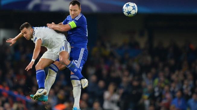 John Terry (kanan) saat melakukan duel udara dengan pemain Dynamo Kiev dalam laga Liga Champions pada 2015 silam. [GLYN KIRK / AFP]