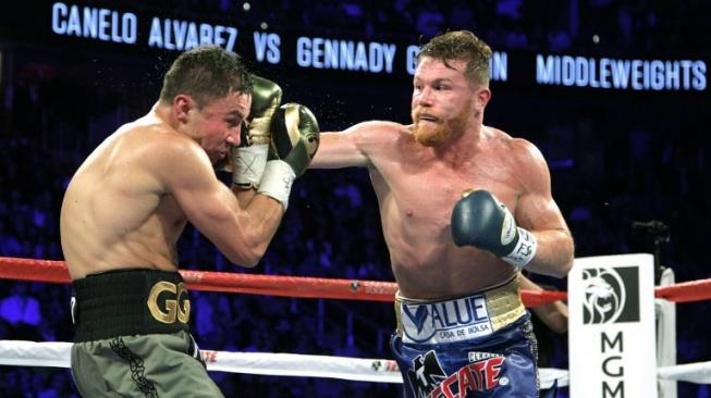 Petinju Meksiko, Saul Alvarez (kanan), melepaskan pukulan hook kanan ke arah wajah petinju Kazakhstan, Gennady vkin, dalam duel di T-Mobile Arena, Las Vegas, AS, Sabtu (16/9/2017). [AFP/John Gurzinski]