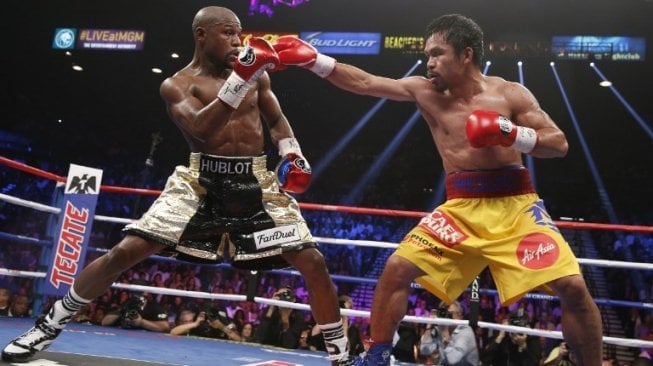 Manny Pacquiao (kanan) melontarkan straight kanan ke arah wajah Floyd Mayweather Jr. Duel yang berlangsung di MGM Grand Garden Arena, AS pada 2 Mei 2015 silam itu dimenangkan Mayweather lewat kemenangan angka mutlak. [AFP/John Gurzinski]