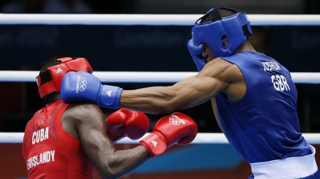 Petinju Britania Raya, Anthony Joshua (kanan), melancarkan pukulan ke arah lawannya dari Kuba, Erislandy Savon Cotilla, dalam pertandingan kelas berat super babak 16 Besar Olimpiade 2012 di ExCel Arena, London, Inggris, 1 Agustus 2012. [AFP/Jack Guez]