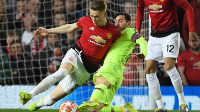 Gelandang sentral Manchester United, Scott McTominay (kiri) berduel dengan megabintang Barcelona, Lionel Messi pada laga leg pertama perempatfinal Liga Champions 2018/2019 di Old Trafford, Kamis (11/4/2019) dini hari WIB. [LLUIS GENE / AFP]