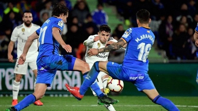 Gelandang Real Madrid Brahim Diaz (C) melepaskan tembakan di antara bek Getafe, Ignasi Miquel (kiri) dan pemain tengah Getafe, Mauro Arambarri dalam laga lanjutan Liga Spanyol Jumat (25/4) dini hari WIB. JAVIER SORIANO / AFP