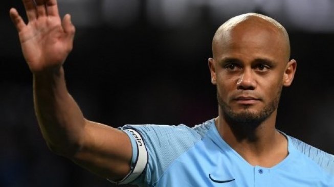 Bek dan juga kapten Manchester City Vincent Kompany melambaikan tangannya kepada suporter setelah membawa timnnya mengalahkan Leicester City. Paul ELLIS / AFP