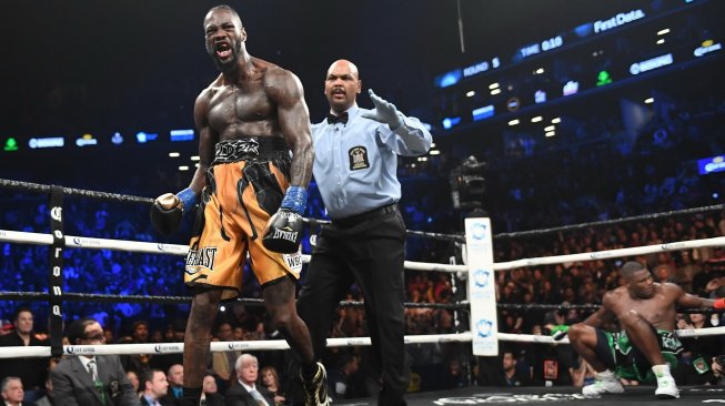 Ekspresi juara dunia kelas berat WBC, Deontay Wilder (kiri), saat menang TKO ronde ke-10 atas penantangnya, Luis Ortiz (kanan), di Barclays Center, New York, AS, Sabtu (3/3/2018). [AFP/Timothy A. Clary]