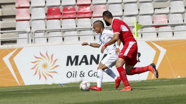 Winger Timnas Indonesia, Riko Simanjuntak (kiri), mencoba melewati pemain Yordania dalam laga uji coba di Stadion King Abdullah, Amman, Yordania, Selasa (11/6/2019). [Dok. PSSI]