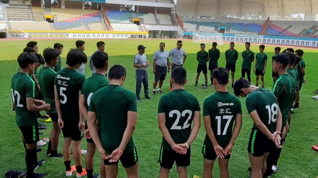 Pelatih Timnas Indonesia U-19 Fakhri Husaini (tengah) memberikan arahan kepada anak asuhnya usai latihan di Stadion Wibawa Mukti, Cikarang, Kamis (13/6/2019). [Suara.com/Adie Prasetyo Nugraha]