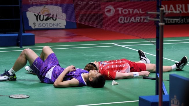 Pebulu tangkis Taiwan Chou Tien Chen (kiri) dan pebulu tangkis Denmark Anders Antonsen (kanan) menjatuhkan diri ke lapangan seusai bertandin pada babak final Blibli Indonesia Open 2019 di Istora Senayan, Jakarta, Minggu (21/7/2019). Tien Chen menjuarai Indonesia Open 2019 nomor tunggal putra usai mengalahkan Antonsen dengan skor 21-18, 24-26, dan 21-15 . ANTARA FOTO/Hafidz Mubarak A