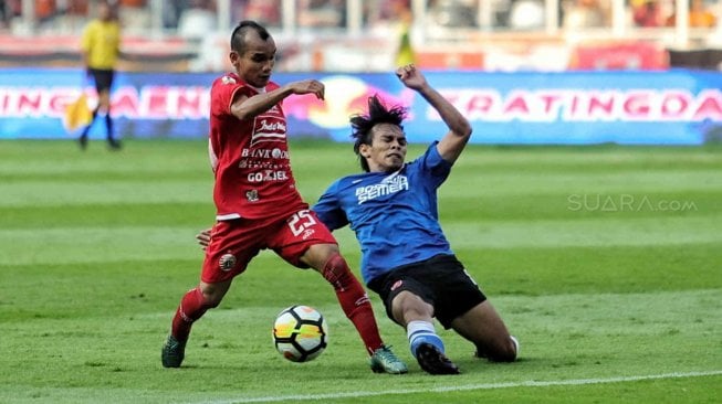 Pesepak bola Persija Jakarta Riko Simanjuntak berusaha melewatu pesepak bola PSM Makassar Rasyid Bakri dalam pertandingan Final Piala Indonesia 2018-2019 leg pertama di Stadion Utama Gelora Bung Karno (GBK), Senayan, Jakarta, Minggu (21/7). [Suara.com/Muhaimin A Untung]