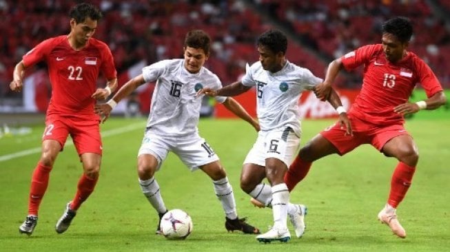 Pemain Timor Leste Paulo Domingos Gali Da Costa Freitas (kedua kiri) berebut bola dengan pemain Singapura di ajang Piala AFF 2018 [AFP]