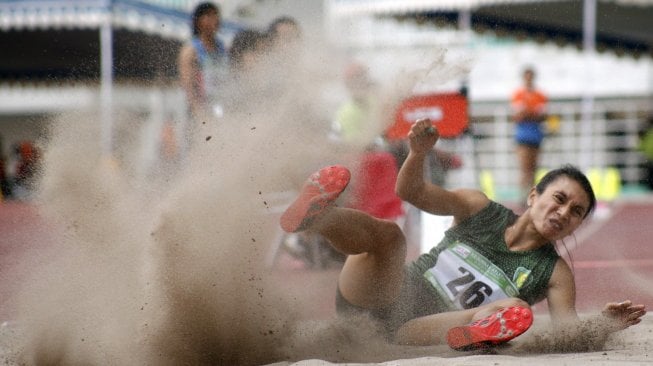 Atlet Maria Natalia Londa asal Bali melakukan lompatan pada final lompat jangkit senior putri dalam Kejuaraan Nasional Atletik 2019 di Stadion Pakansari, Cibinong, Jawa Barat, Rabu (7/8). [Antara/Yulius Satria Wijaya]