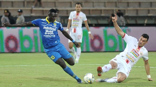 Pesepak bola Persib Bandung Ezechiel Ndouasel (kiri) berebut bola dengan pesepak bola Persija Jakarta Alexandre Luiz Reame (kanan) saat pertandingan Liga 1 2019 di Stadion Kapten I Wayan Dipta, Gianyar, Bali, Senin (28/10/2019). Dalam pertandingan tersebut, Persib Bandung berhasil mengalahkan Persija Jakarta dengan skor 2-0. ANTARA FOTO/Fikri Yusuf/foc.