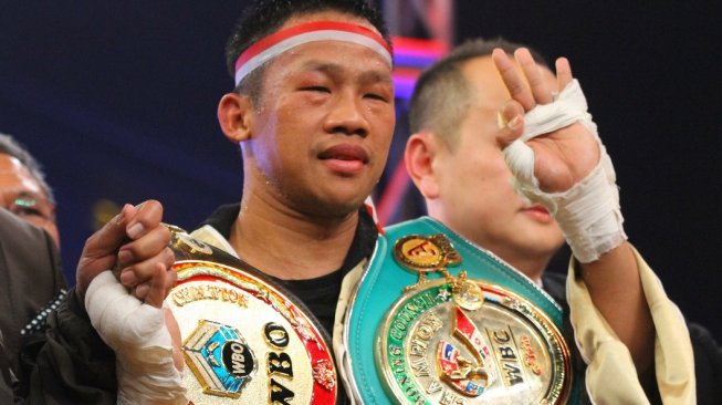 Petinju Indonesia Daud Yordan melakukan selebrasi usai mengalahkan Michael Mokoena (Afrika Selatan) dalam perebutan sabuk juara dunia tinju kelas ringan super IBA dan WBO Oriental di Batu, Jawa Timur, Minggu (17/11/2019). [Antara/Ari Bowo Sucipto]