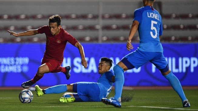 Pemain Timnas U-22 Indonesia Egy Maulana Vikri (kiri) menggiring bola melewati pemain Timnas Singapura Muhammad Syahrul Bin Sazali (tengah) dan Lionel Tan dalam pertandingan Grup B SEA Games 2019 di Stadion Rizal Memorial, Manila, Filipina, Kamis (28/11/2019). Indonesia mengalahkan Singapura dengan skor 2-0. ANTARA FOTO/Sigid Kurniawan/foc.