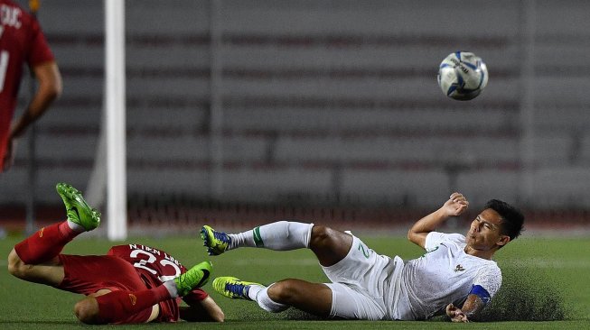 Pemain Timnas U-22 Indonesia Andy Setyo (kanan) terjatuh saat berebut bola dengan pemain Timnas Vietnam Nguyen Tien Linh dalam pertandingan Grup B SEA Games 2019 di Stadion Rizal Memorial, Manila, Filipina, Minggu (1/12). [ANTARA FOTO/Sigid Kurniawan]