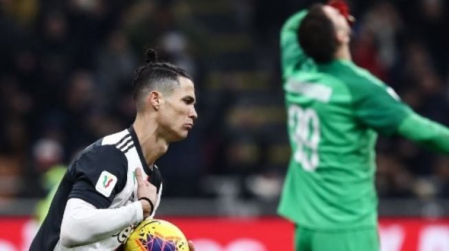 Pemain Juventus Cristiano Ronaldo mengambil bola setelah menjebol gawang AC Milan dari titik penalti di leg pertama semifinal Coppa Italia. Isabella BONOTTO / AFP 