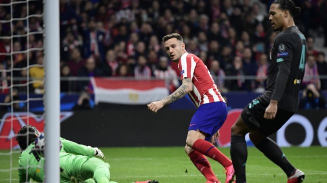 Momen gelandang serang Atletico Madrid, Saul Niguez (tengah) mencetak gol ke gawang Liverpool, sementara bek Liverpool Virgil van Dijk (kanan) hanya bisa melihatnya pada laga Liga Champions 2019/2020 di Estadio Wanda Metropolitano, Madrid, Rabu (19/12/2020) dini hari WIB. [JAVIER SORIANO / AFP] 