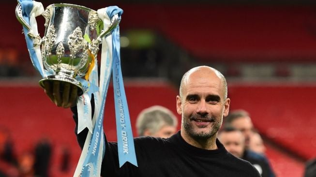 Manajer Manchester City, Pep Guardiola usai membawa timnya juara Piala Liga Inggris 2019/2020 di Stadion Wembley, London, Senin (2/3/2020) dini hari WIB. Man City mengalahkan Aston Villa 2-1 di laga final. [Glyn KIRK / AFP]