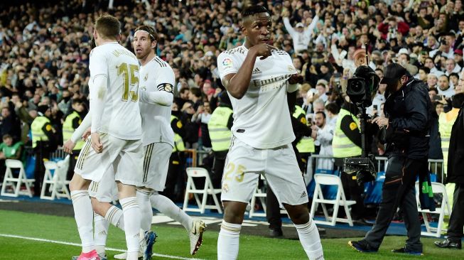 Pemain depan Real Madrid, Vinicius Junior (R) merayakan golnya dengan rekan satu tim setelah mencetak gol selama pertandingan sepak bola Liga Spanyol antara Real Madrid melawan Barcelona di Stadion Santiago Bernabeu, Madrid, Spanyol, Senin (2/3) dini hari WIB. [OSCAR DEL POZO / AFP