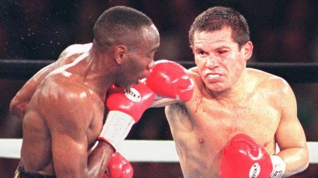 Legenda tinju dunia asal Meksiko, Julio Cesar Chavez (kanan), mendaratkan pukulan hook ke wajah penantangnya, David Kamau, dalam pertarungan kelas ringan super WBC di Mirage Hotel and Casino, Las Vegas, pada 16 September 1995. [AFP/Clint Karlsen]