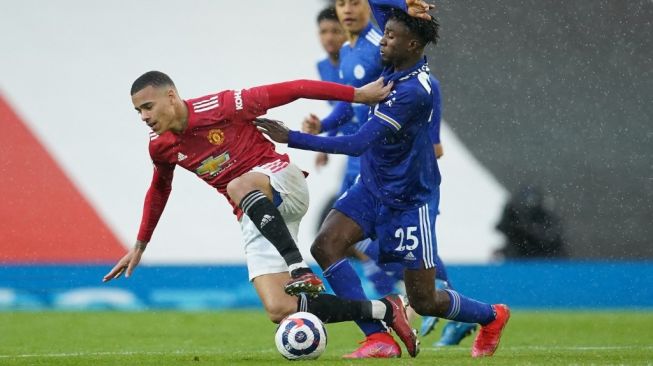 Penyerang Manchester United, Mason Greenwood berebut bola dengan para pemain Leicester City dalam laga pekan ke-36 Liga Inggris di Old Trafford, Rabu (12/5/2021) dini hari WIB. [Dave Thompson / POOL / AFP].