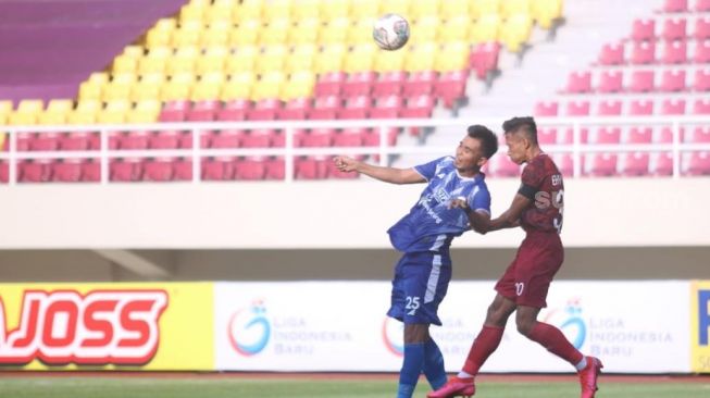 Bek Persis Solo, Eky Taufik (kanan) berduel udara dengan pemain PSCS Cilacap, Rachmat Latief dalam lanjutan Grup C Liga 2 di Stadion Manahan, Selasa (26/10/2021). [Suara.com/Ronald Seger Prabowo]