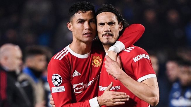 Penyerang Manchester United, Cristiano Ronaldo bercengkerama dengan penyerang Edinson Cavani usai laga Liga Champions kontra Atalanta di Gewiss Stadium, Bergamo, Italia, Rabu (3/11/2021) pagi WIB. [Marco BERTORELLO / AFP]