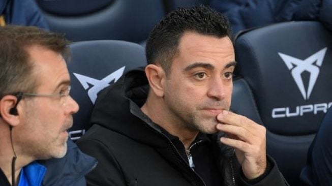 Pelatih Barcelona Xavi Hernandez menyaksikan timnya berlaga di ajang La Liga menghadapi Real Betis di Camp Nou pada 4 Desember 2021. [AFP]