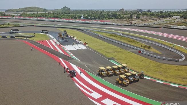 Foto udara sejumlah pekerja mengerjakan pengaspalan ulang tikungan ke-17 lintasan Pertamina Mandalika International Street Circuit di KEK Mandalika, Kecamatan Pujut, Praya, Lombok Tengah, NTB, Sabtu (5/3/2022). ANTARA FOTO/Ahmad Subaidi/wsj.