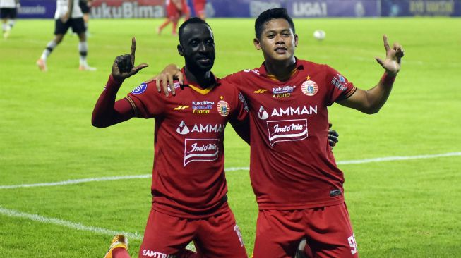 Pesepak bola Persija Jakarta Makan Konate (kiri) bersama Taufik Hidayat (kanan) berselebrasi usai mencetak gol ke gawang Persikabo 1973 pada pertandingan Liga 1 di Stadion Kompyang Sujana, Denpasar, Bali, Minggu (13/3/2022). [ANTARA FOTO/Nyoman Hendra Wibowo/hp]