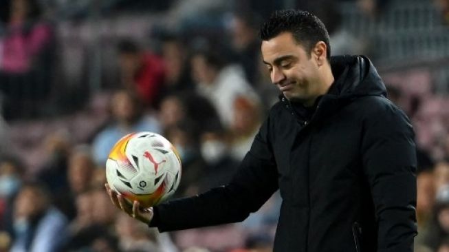 Pelatih Barcelona Spanyol Xavi Hernandez memegang bola pada pertandingan sepak bola Liga Spanyol antara FC Barcelona dan Cadiz CF di stadion Camp Nou di Barcelona pada 18 April 2022.LLUIS GEN/AFP