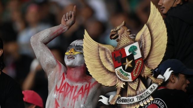 Seorang suporter membawa lambang Garuda Pancasila saat memberikan dukungan untuk Tim Nasional Indonesia U-19 melawan Tim Nasional Vietnam U-19 dalam laga penyisihan Grup A Piala AFF U-19 2022 di Stadion Patriot Candrabhaga, Bekasi, Jawa Barat, Sabtu (2/7/2022). Skor pertandingan berakhir seri 0-0. ANTARA FOTO/Aditya Pradana Putra/rwa.