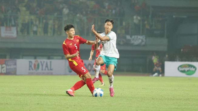 Pemain timnas Indonesia U-19, Alfriyanto Nico (kanan) berebut bola dengan pemain Vietnam dalam matchday pertama Grup A Piala AFF U-19 2022 di Stadion Patriot Candrabhaga, Bekasi, Sabtu (2/7/2022). [PSSI]