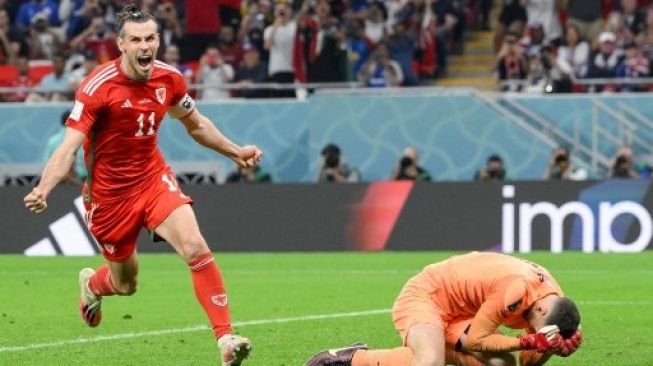 Penyerang #11 Wales Gareth Bale merayakan golnya pada pertandingan sepak bola Grup B Piala Dunia Qatar 2022 antara Amerika Serikat dan Wales di Stadion Ahmad Bin Ali di Al-Rayyan, barat Doha pada 21 November 2022. NICOLAS TUCAT / AFP